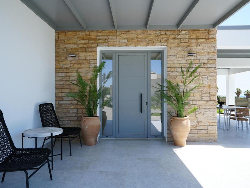 Stone-clad villa entrance with potted palms