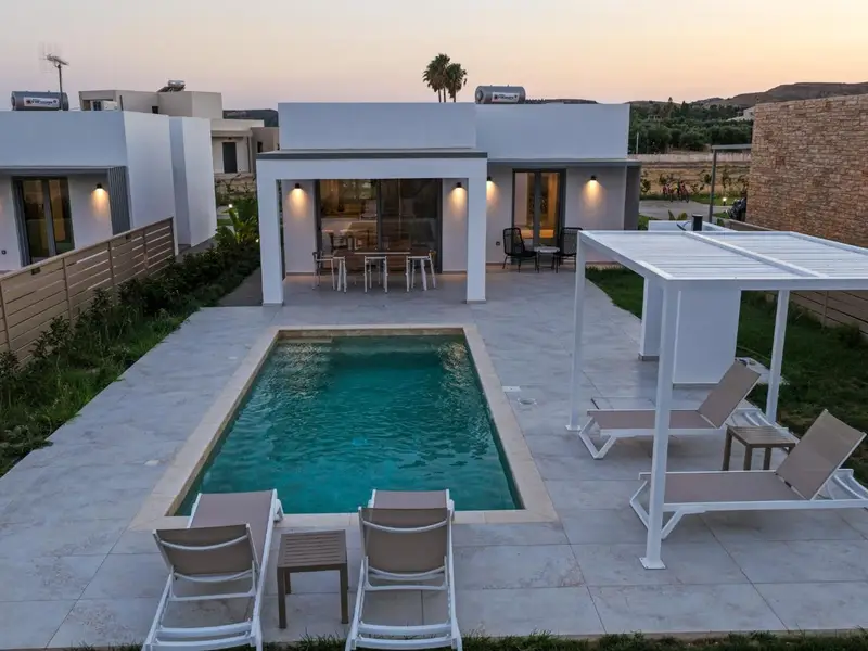 Private pool and shaded pergola lit at dusk