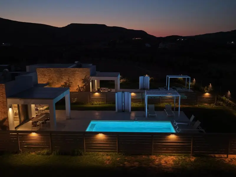 Lit stone wall and pool after sunset