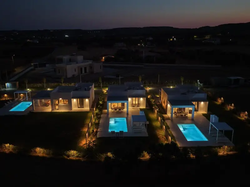 Two villas and their pools at dusk