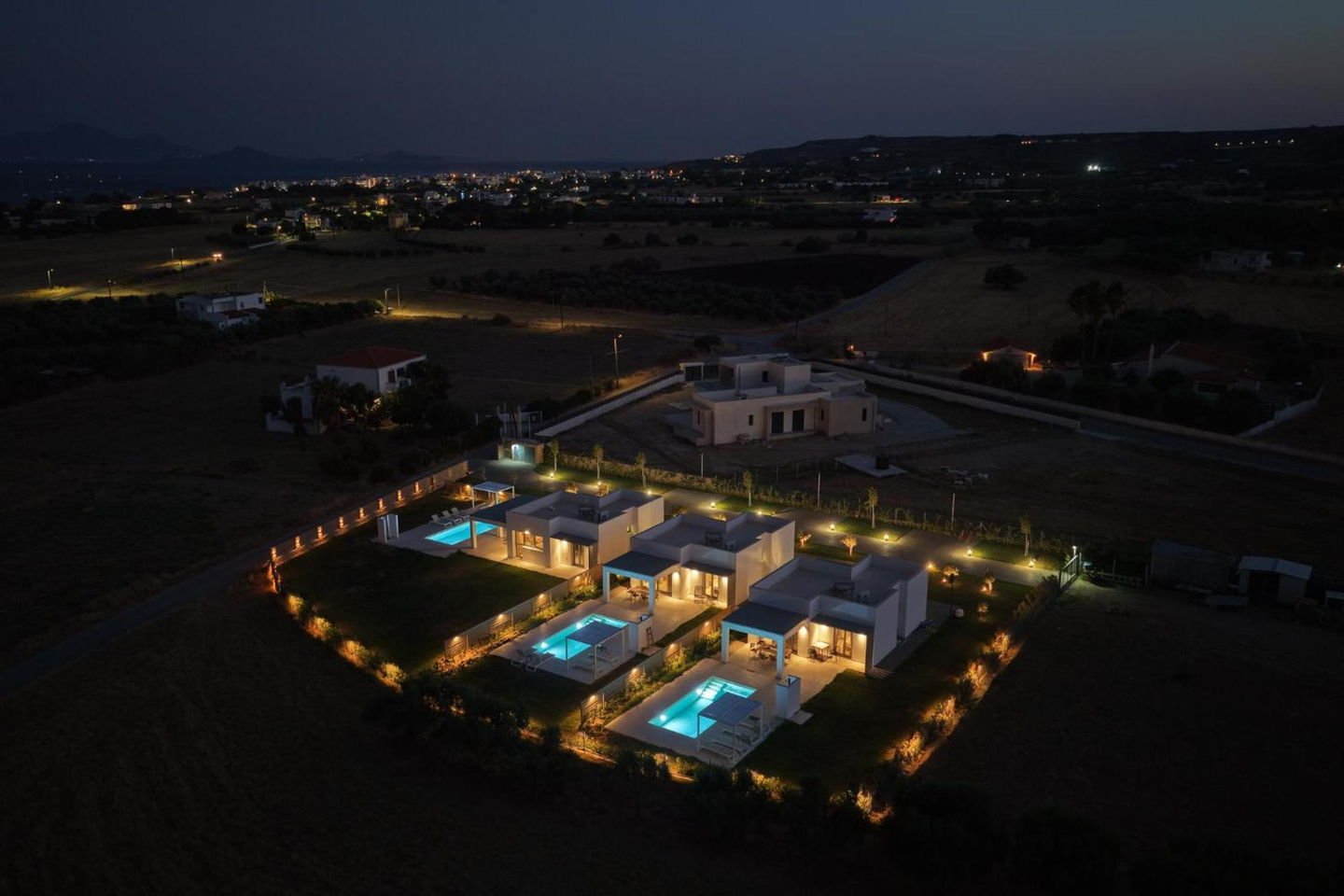 The villas and their pools illuminated after sunset