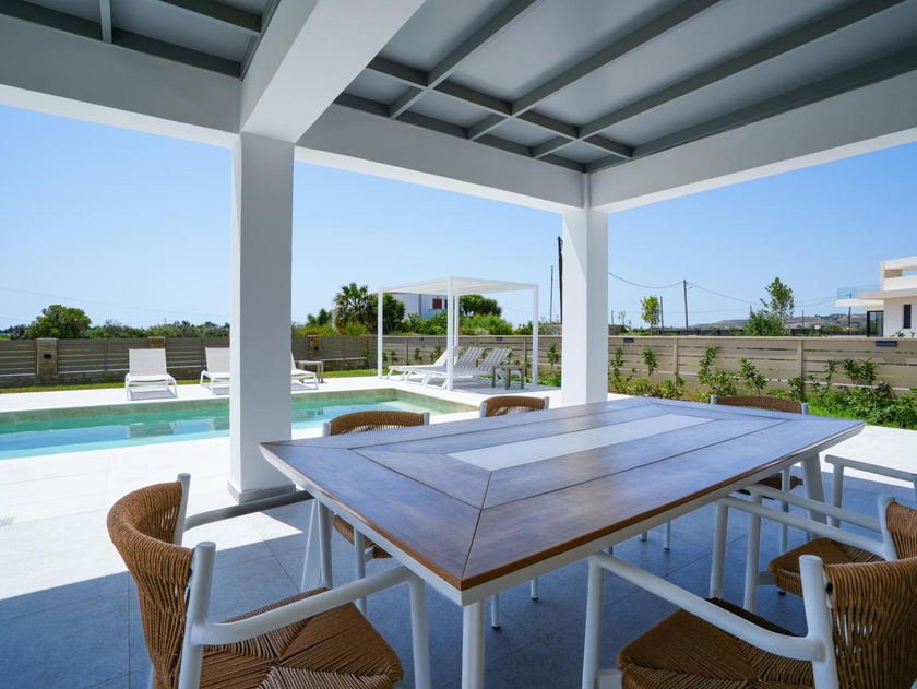 Outdoor dining table shaded by the pergola